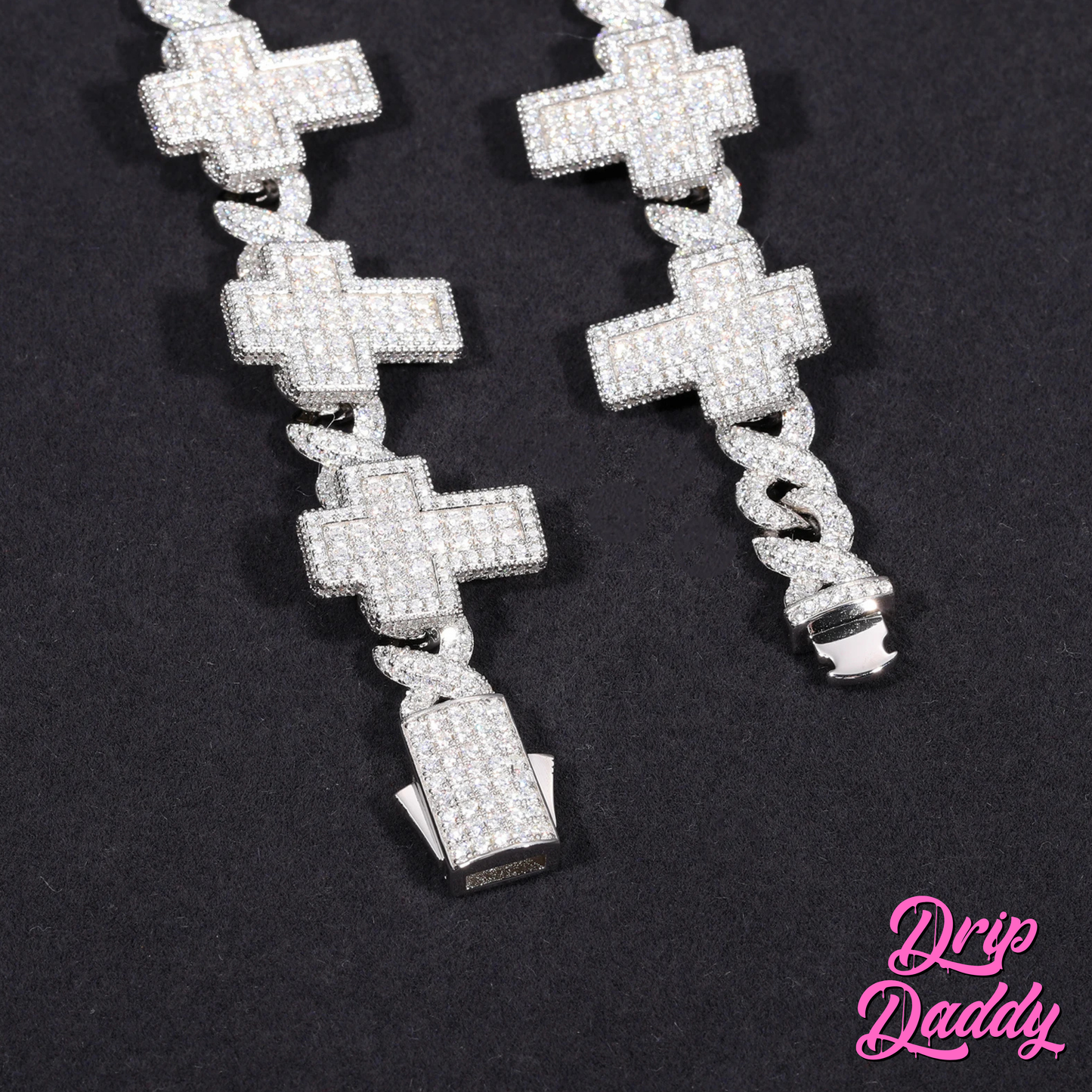Close-up of Drip Daddy’s Crucifix Link – 8mm Moissanite Chain in white gold plating, showcasing the fully iced crucifix links and box clasp against a black background, with the pink Drip Daddy logo in the bottom right corner.