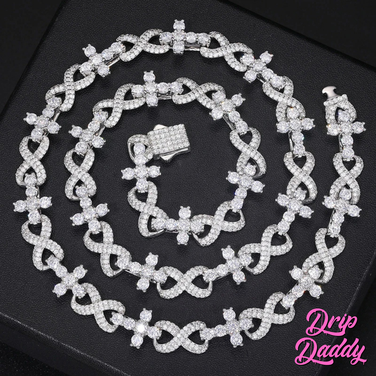 Close-up of Drip Daddy’s Infinity Link chain set in white gold with iced-out moissanite stones, displayed flat on a black background with the pink Drip Daddy logo visible in the corner.