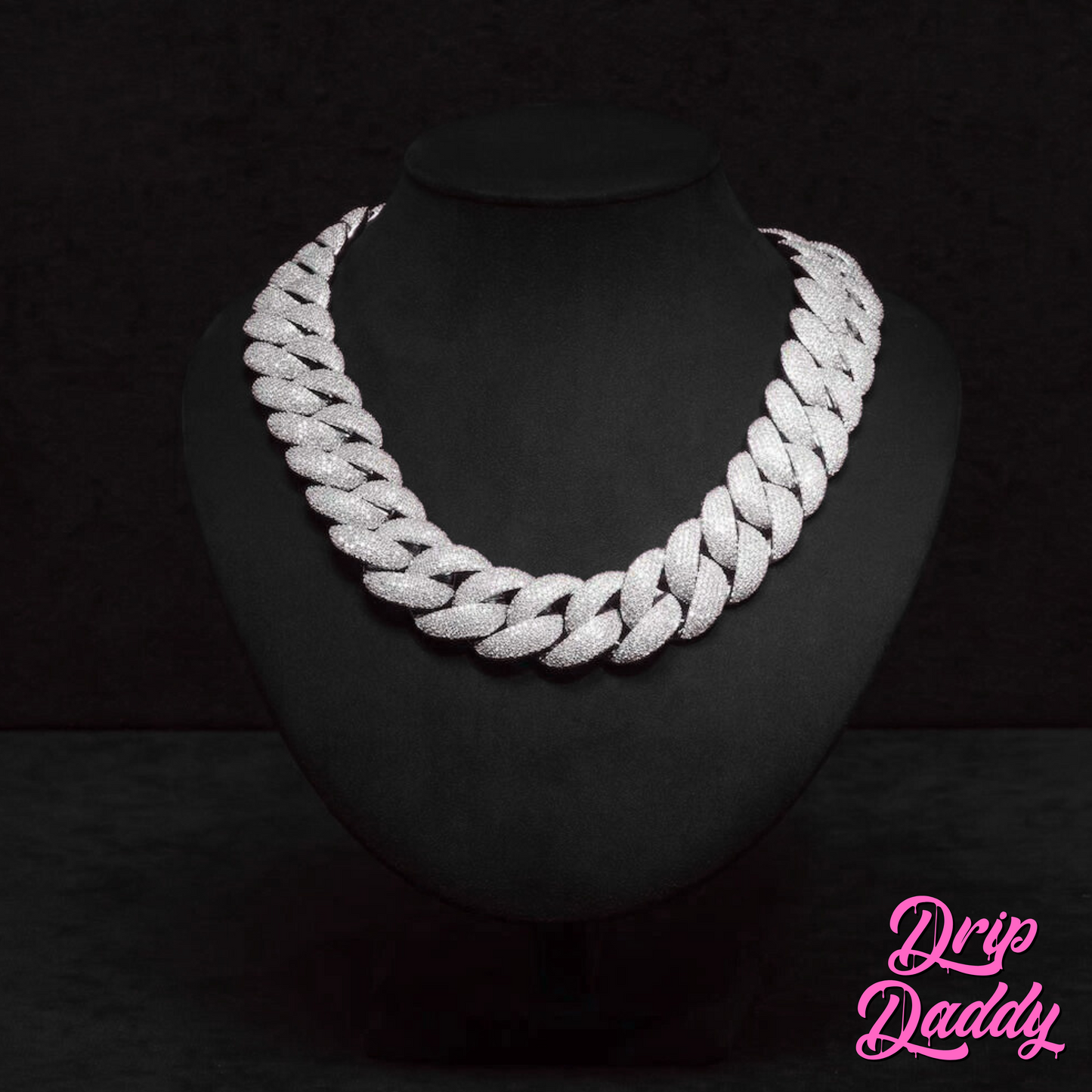 Close-up of Drip Daddy’s The Heavy Hitter 20mm to 30mm Moissanite Miami Cuban Link Chain in white gold plated finish, displayed on a black jewelry mannequin with the Drip Daddy logo in pink in the bottom right corner.
