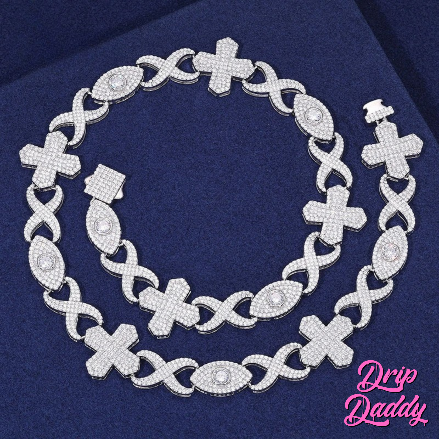 The Drip Daddy Evil Eye Cross Link – 12mm Moissanite Chain in full view, featuring alternating cross and eye-shaped links with moissanite stones, displayed on a dark blue fabric background.