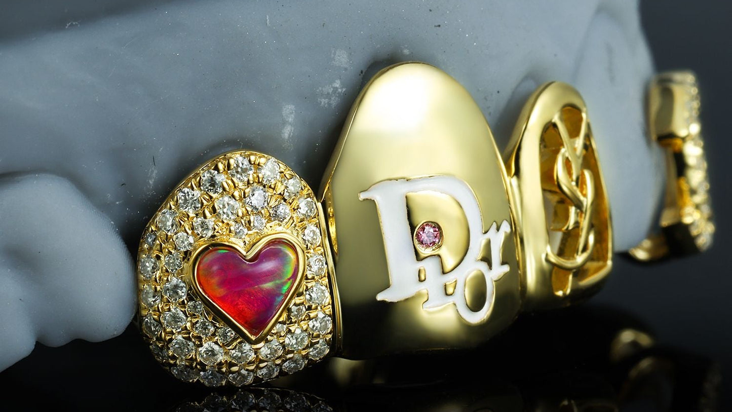 Custom gold grillz with diamond heart, Dior enamel detail, and gemstone accents by Drip Daddy.