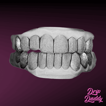 Full top and bottom grillz with diamond dust finish in polished 925 sterling silver, shown on a dental mold, by Drip Daddy.