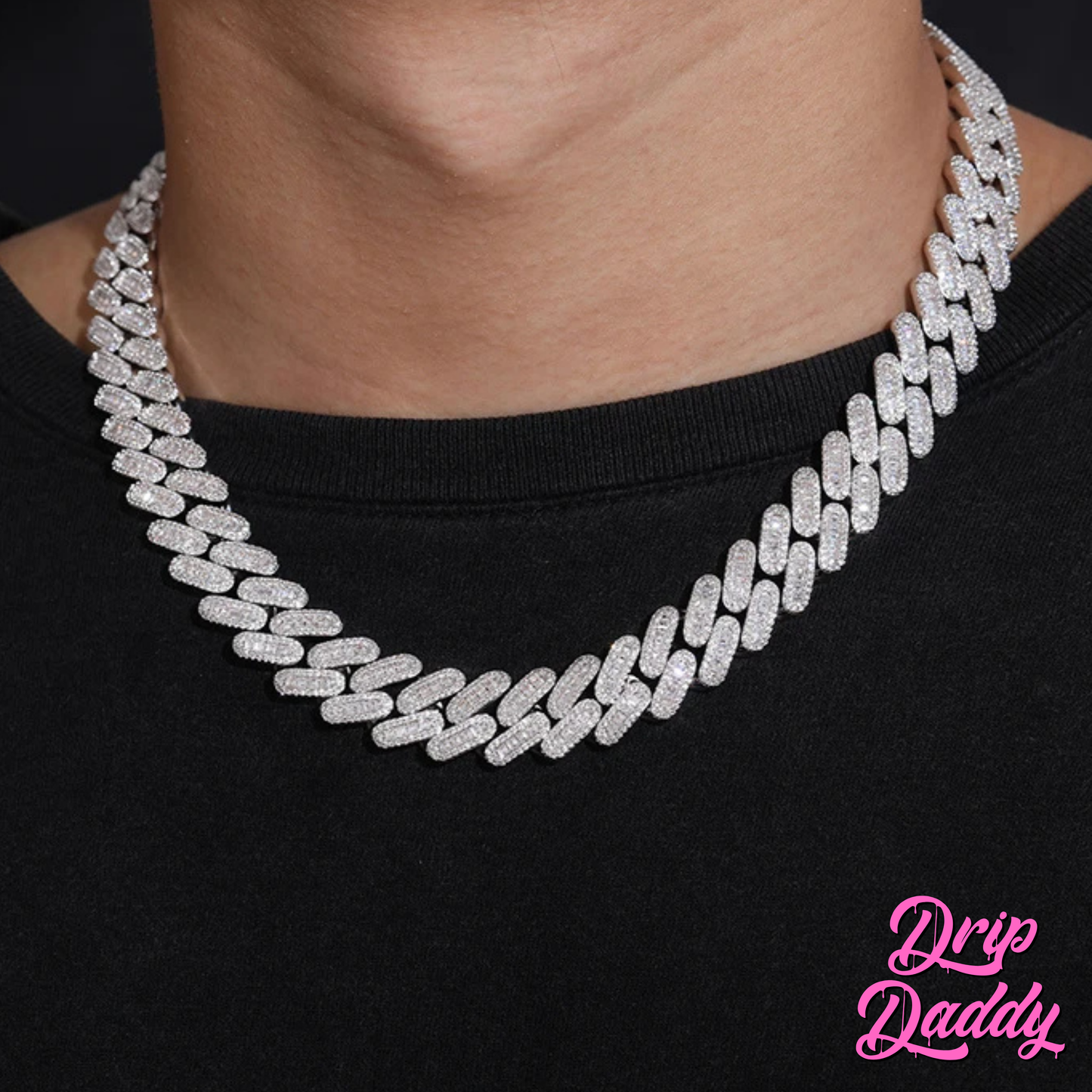 A person wearing Drip Daddy’s Capsule – Mixed-Cut Cuban Chain in 14mm white gold plating over a black shirt. The diamond-encrusted design sparkles under lighting, with the Drip Daddy logo in pink at the bottom right.
