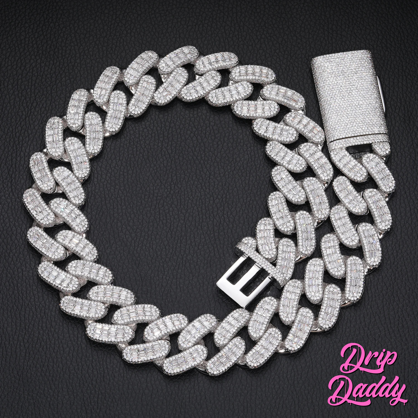 Drip Daddy’s Capsule – Mixed-Cut Cuban Chain in 28mm white gold plating, displayed coiled on a black textured surface with its diamond-studded clasp visible. The Drip Daddy logo is placed in pink at the bottom right.