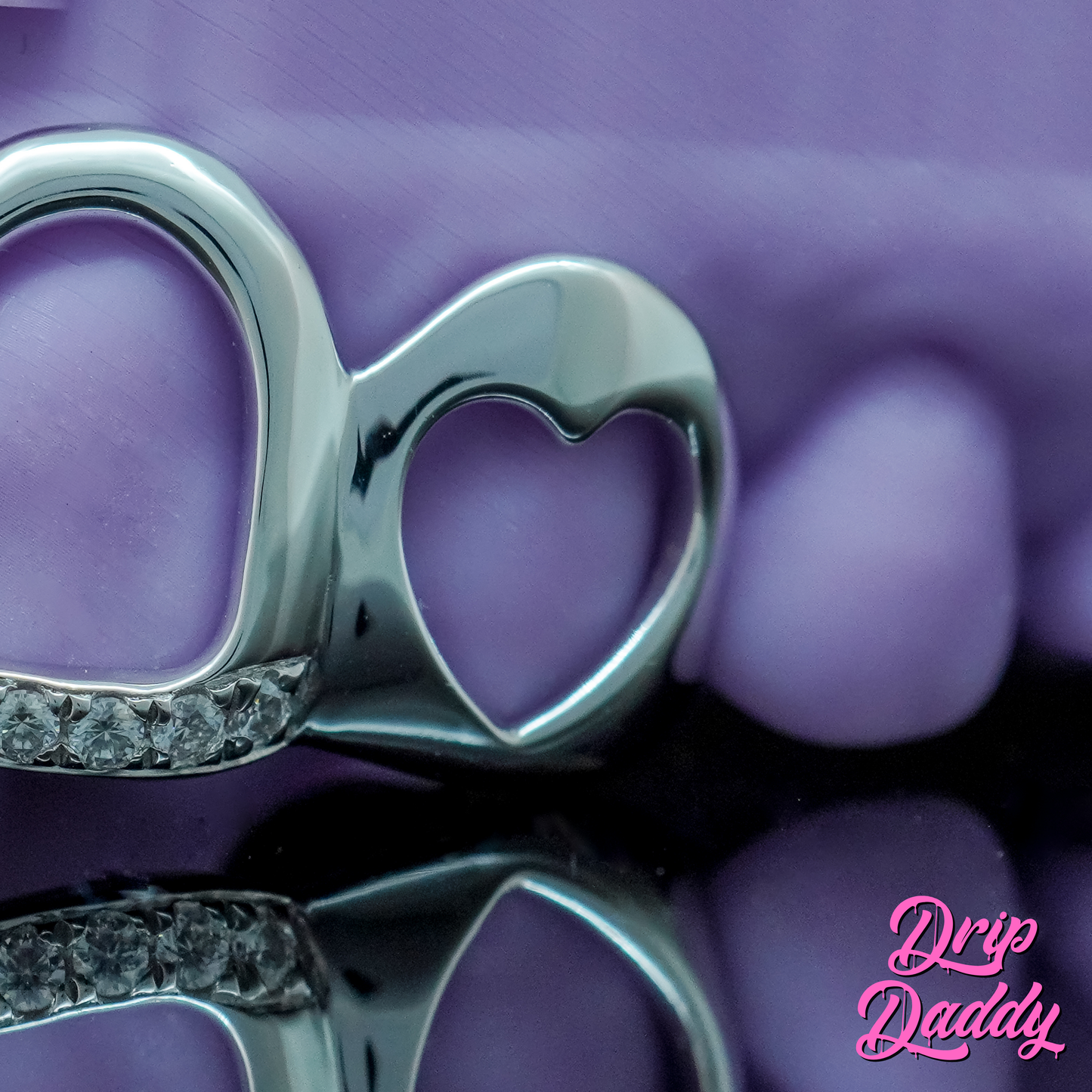 Drip Daddy Cut-Out Grillz featuring a silver heart design, set against a purple background and watermarked with the Drip Daddy logo.