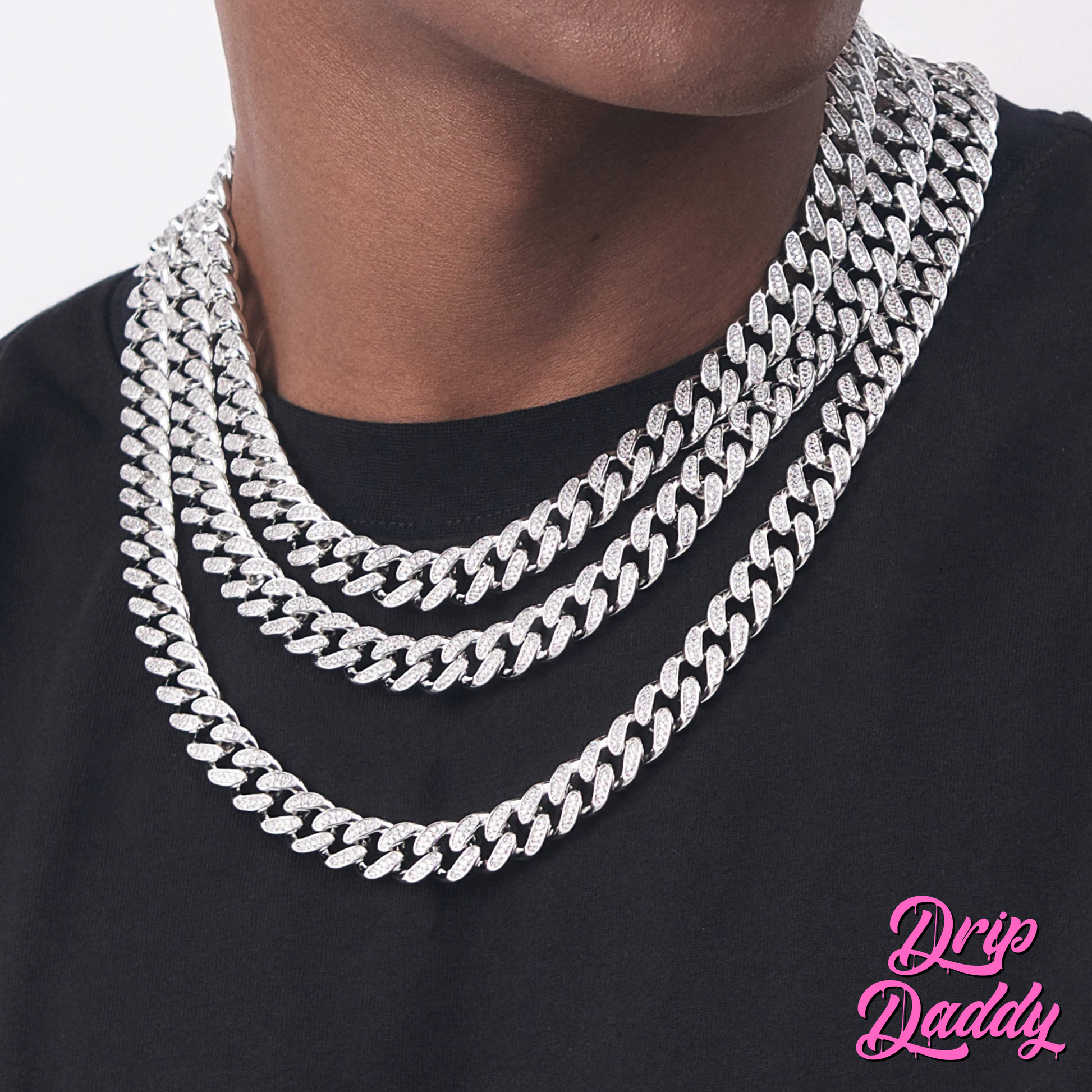 Close-up of Drip Daddy’s Frosted Miami Cuban Link Chain set in varying sizes from 8mm to 18mm, crafted in white gold plating with moissanite stones, displayed in a row on a black surface with the Drip Daddy logo in pink at the bottom right.