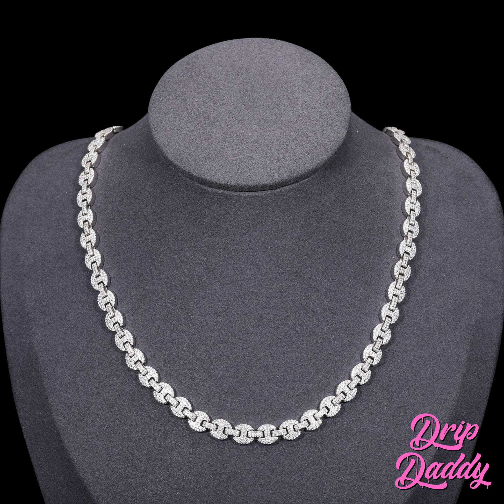 A mannequin wearing Drip Daddy’s Gemlock Link chain in 6mm to 10mm size, crafted in white gold plating with moissanite stones, displayed against a black background with the Drip Daddy logo in pink at the bottom right.
