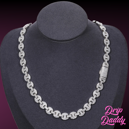 A mannequin wearing Drip Daddy’s Gemlock Link chain in 6mm to 10mm size, crafted in white gold plating with moissanite stones, shown with the clasp visible on the right side, against a dark gradient background with the Drip Daddy logo in pink at the bottom right.