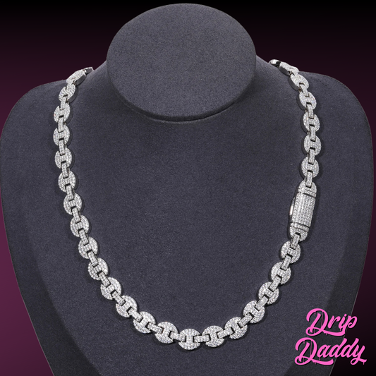 A mannequin wearing Drip Daddy’s Gemlock Link chain in 6mm to 10mm size, crafted in white gold plating with moissanite stones, shown with the clasp visible on the right side, against a dark gradient background with the Drip Daddy logo in pink at the bottom right.