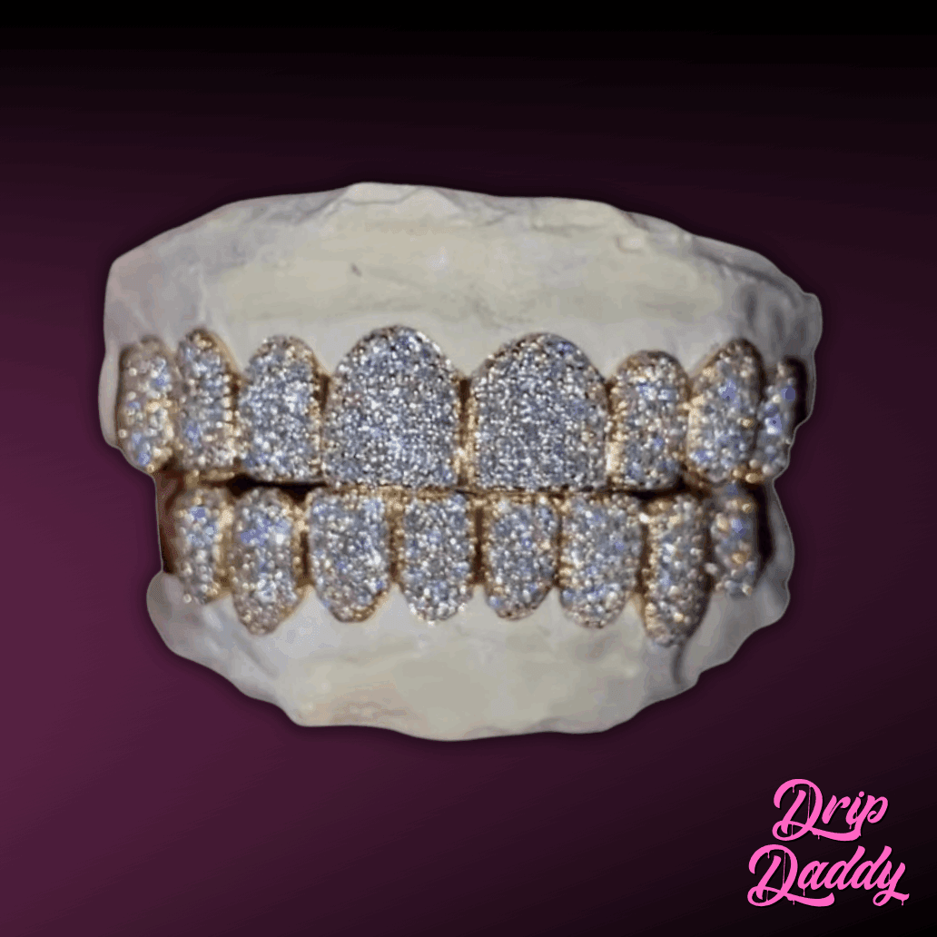 Custom iced out grillz by Drip Daddy, featuring 925 sterling silver with yellow gold plating, fully set with moissanite stones. Sparkling hip hop jewelry piece showcased on a plaster mold against a dark purple background.