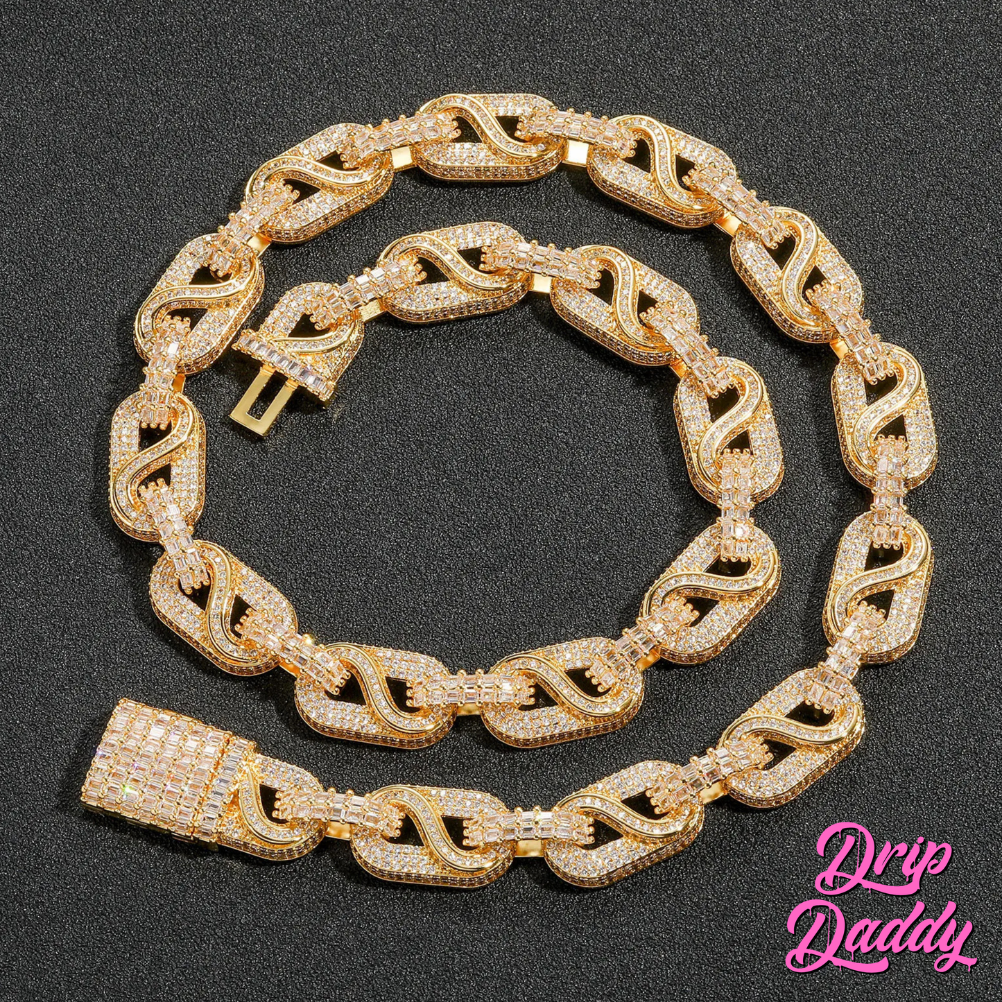 The Snowdrift – 14mm Baguette & Round Moissanite Link Chain in yellow gold plating by Drip Daddy, iced-out and coiled flat on a black surface with the Drip Daddy logo in pink.