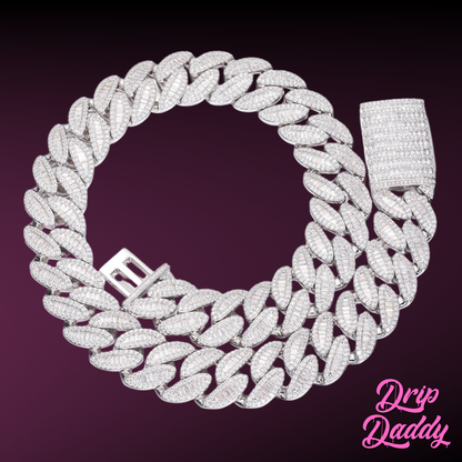 Close-up of Drip Daddy’s The Enforcer 20mm Mixed-Cut Cuban Link Chain in white gold with diamond detailing, displayed on a purple background with the Drip Daddy logo in pink at the bottom right corner.