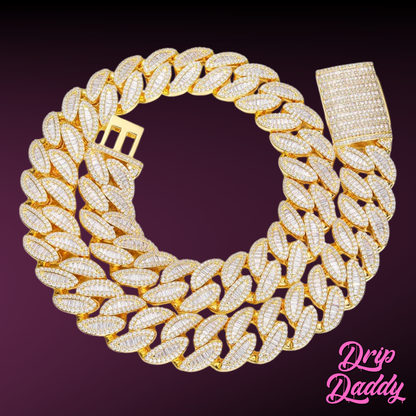 Close-up of Drip Daddy’s The Enforcer 20mm Mixed-Cut Cuban Link Chain in yellow gold with diamond detailing, displayed on a purple background with the Drip Daddy logo in pink at the bottom right corner.