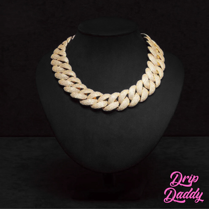 Close-up of Drip Daddy’s The Heavy Hitter 20mm to 30mm Moissanite Miami Cuban Link Chain in yellow gold plated finish, displayed on a black jewelry mannequin with the Drip Daddy logo in pink in the bottom right corner.