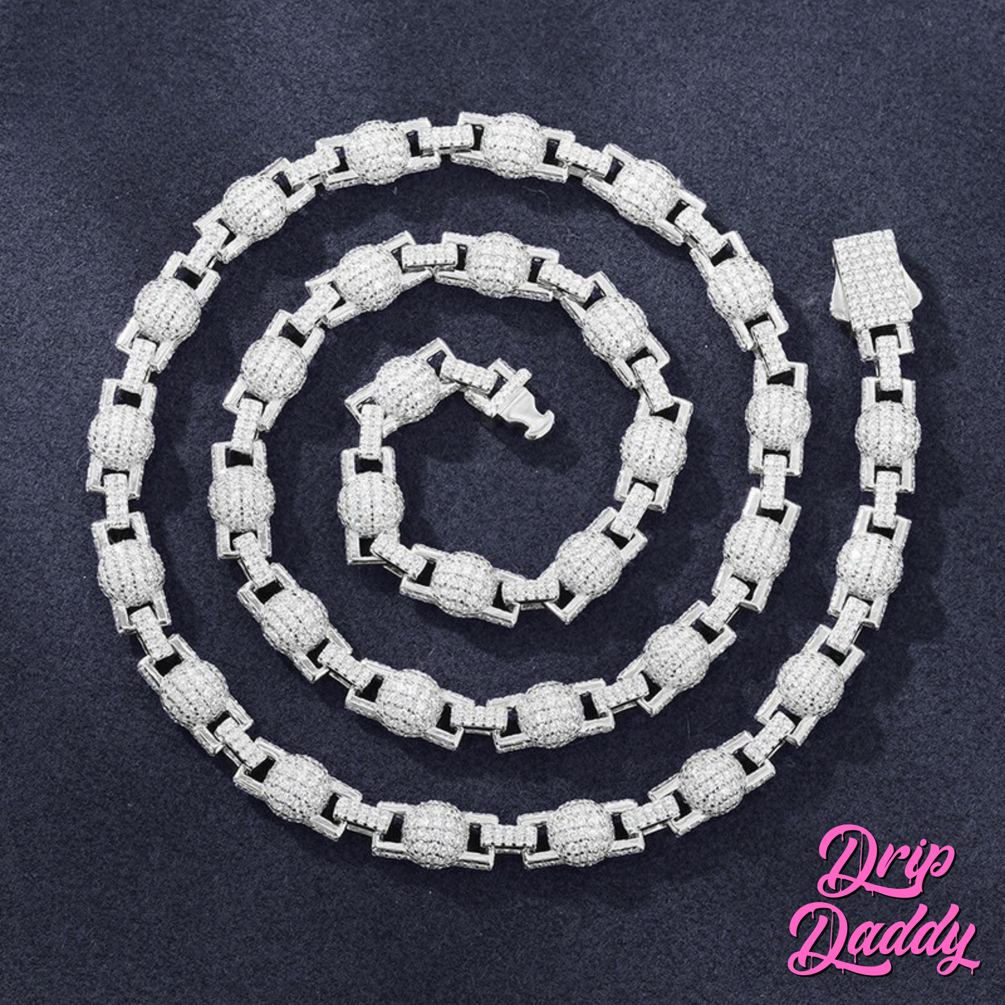 Close-up of Drip Daddy’s The Juggernaut – 7mm Moissanite Bead Link Chain in white gold plating, arranged in a spiral on a dark textured background with the Drip Daddy logo in pink at the bottom right.