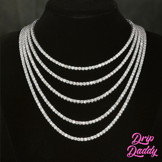 A display bust features a sparkling Drip Daddy Moissanite Tennis Chain (3mm–6mm, white, yellow, and rose gold plated). The Drip Daddy logo is in pink at the bottom right.
