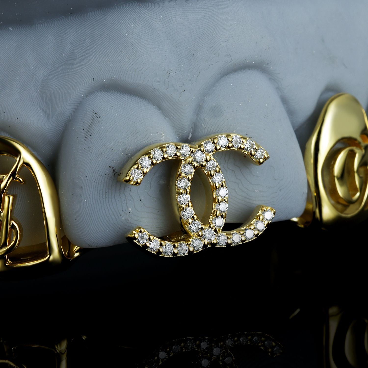 Custom Chanel inspired grillz in gold with diamond logo design, handcrafted by Drip Daddy.