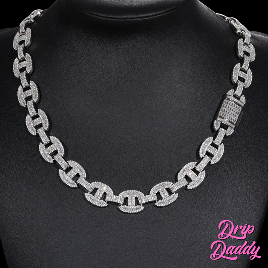 The Drip Daddy G-Link – 16mm Baguette Moissanite Chain is displayed on a black mannequin bust, showing its full white gold design with a fully iced clasp. The Drip Daddy logo appears in pink at the lower right corner.