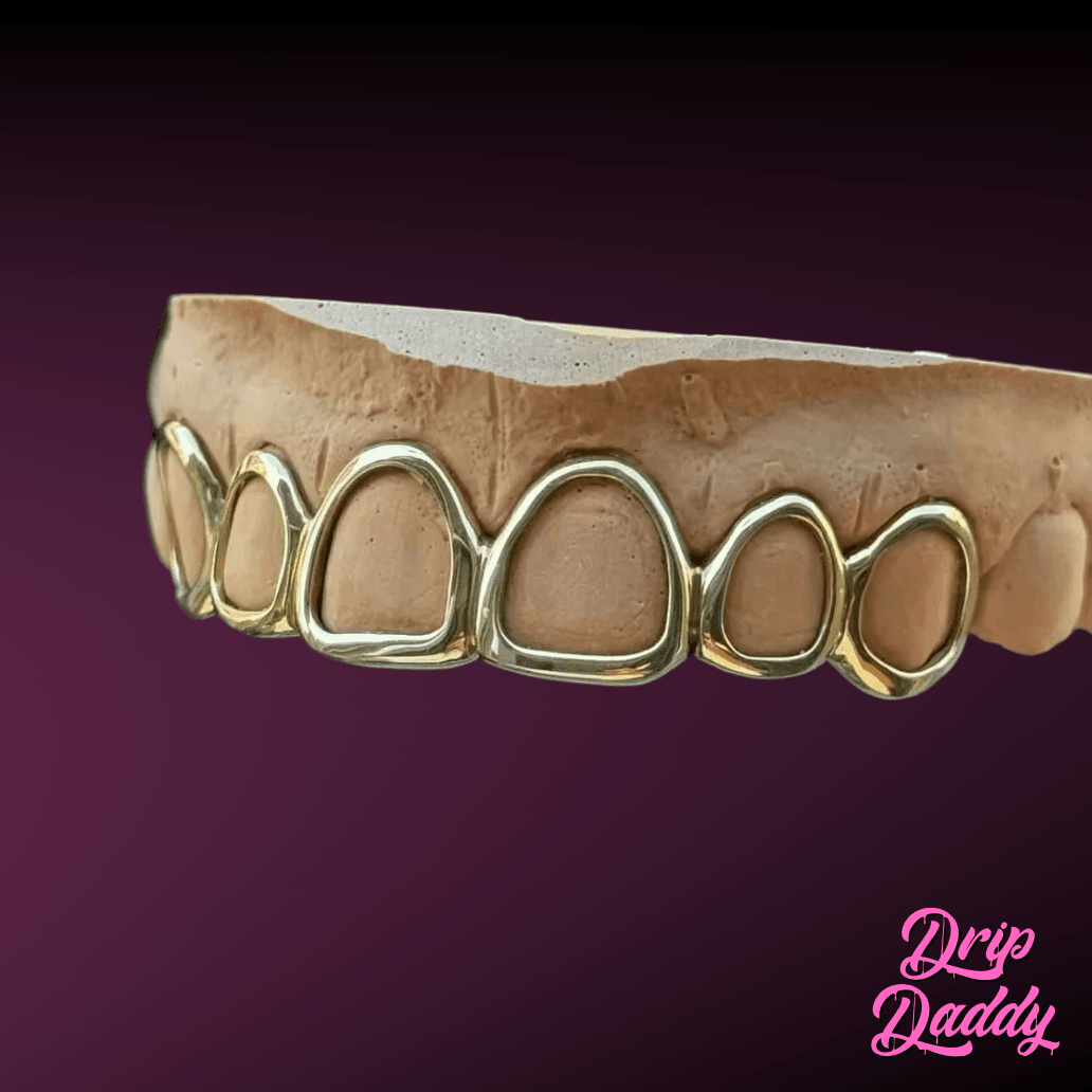 Custom Open Face Window Grillz in yellow-gold plating on 925 sterling silver, upper row only captured from a side angle, against a purple gradient with Drip Daddy branding.