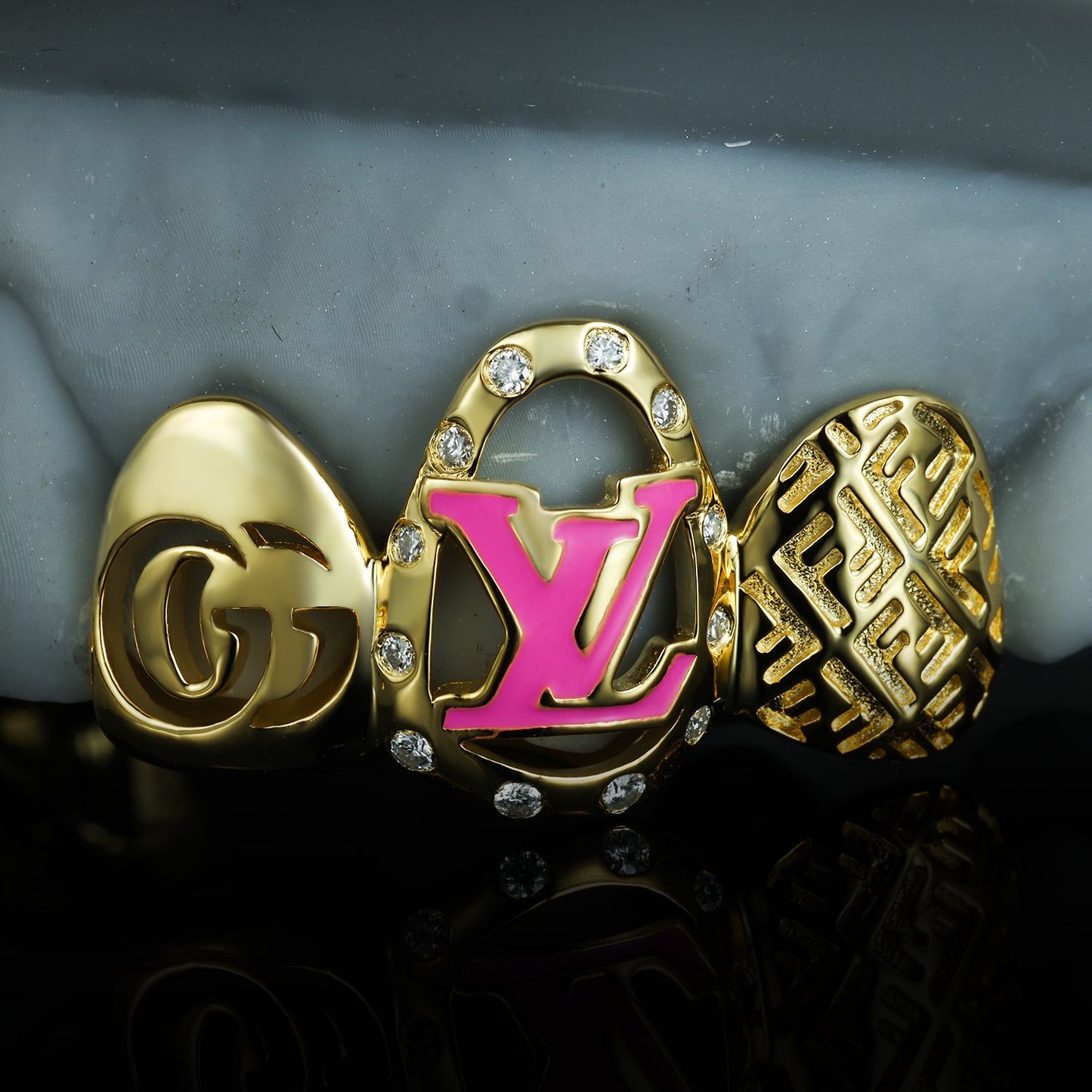 High-end gold grillz with Gucci, Louis Vuitton, and Fendi inspired designs by Drip Daddy.