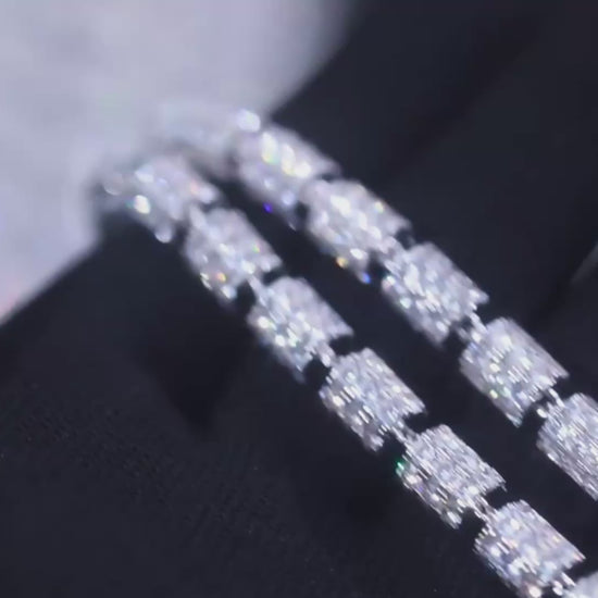 Close-up video of the Stargazer Cylinder 7mm moissanite chain. The camera pans across cylindrical links, each set with brilliant moissanite stones that sparkle under studio lighting. The polished silver finish enhances the shimmer of the stones, highlighting the chain’s unique modern design. The chain rotates smoothly to capture reflections and fine details, showcasing luxury craftsmanship and high-end shine.