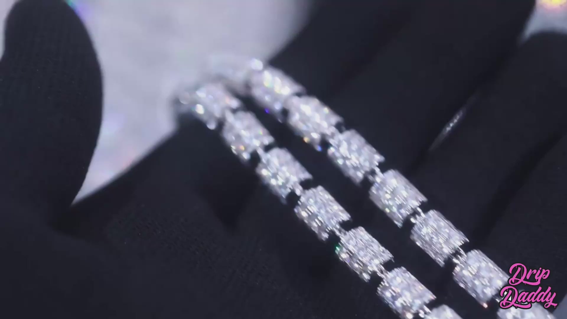 Close-up video of the Stargazer Cylinder 7mm moissanite chain. The camera pans across cylindrical links, each set with brilliant moissanite stones that sparkle under studio lighting. The polished silver finish enhances the shimmer of the stones, highlighting the chain’s unique modern design. The chain rotates smoothly to capture reflections and fine details, showcasing luxury craftsmanship and high-end shine.