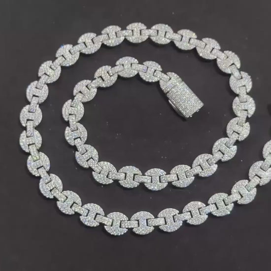 High–definition video showcasing the Gemlock Link chain, featuring alternating 6mm to 10mm links fully iced with moissanite stones. The chain sparkles under studio lighting, highlighting the unique gem–set design and luxury white gold plated finish.