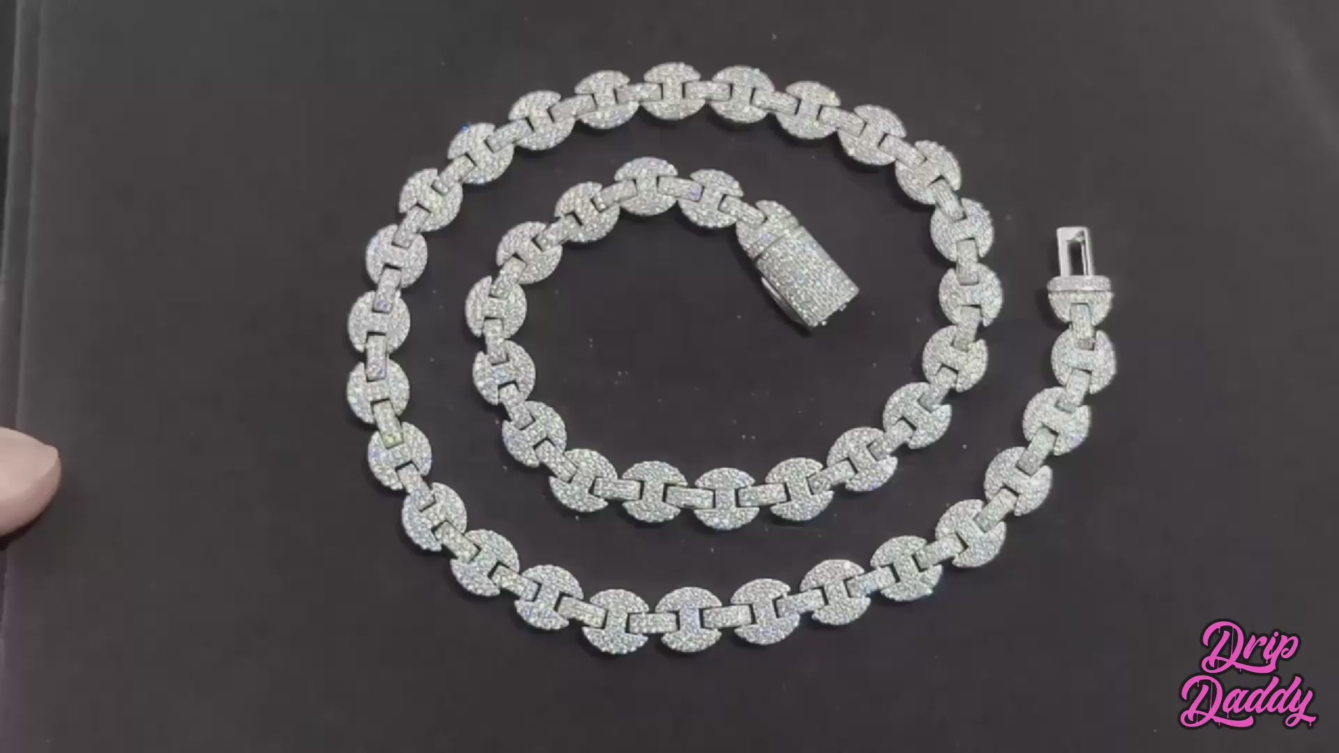 High–definition video showcasing the Gemlock Link chain, featuring alternating 6mm to 10mm links fully iced with moissanite stones. The chain sparkles under studio lighting, highlighting the unique gem–set design and luxury white gold plated finish.