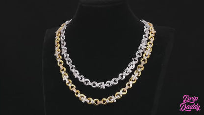 A studio-lit video showcasing Drip Daddy’s The Infinity Cross Plain Chain. The camera pans across the chain, highlighting its polished finish and clean design against a dark background, with the Drip Daddy logo visible in the corner.