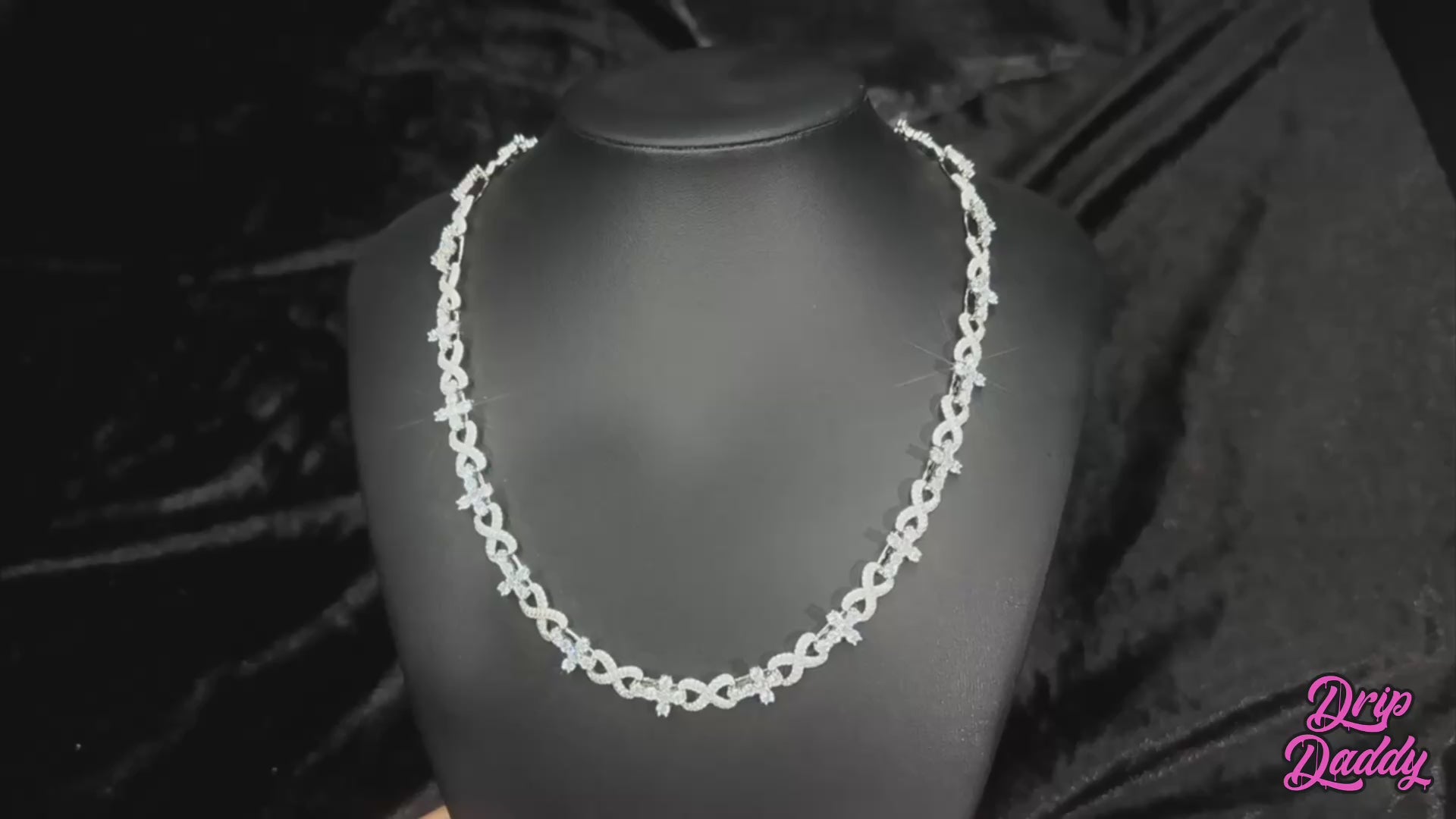 A product video of Drip Daddy’s Infinity Cross Plain – 10mm Mixed Link Chain in yellow gold plating. The video showcases the chain’s details and shine with close-up angles. The Drip Daddy logo is visible in pink at the bottom right.