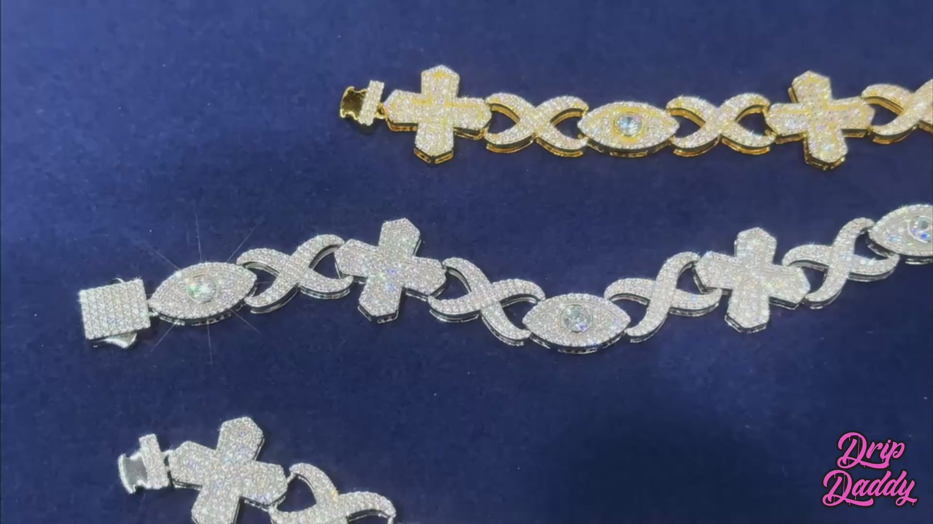 Promotional video of the Drip Daddy Evil Eye Cross Link – 12mm Moissanite Chain, rotating views in yellow gold and white gold, showing intricate cross and eye link design under studio lighting.