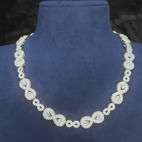 Video of the Eternal Drip – 12mm Moissanite Chain, showing a close-up of the chain under studio lighting. The camera pans smoothly across the links, highlighting the precision-set moissanite stones and their high sparkle. The white gold plated finish reflects light with a polished shine, giving the chain a luxurious, icy look