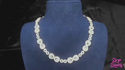 Video of the Eternal Drip – 12mm Moissanite Chain, showing a close-up of the chain under studio lighting. The camera pans smoothly across the links, highlighting the precision-set moissanite stones and their high sparkle. The white gold plated finish reflects light with a polished shine, giving the chain a luxurious, icy look