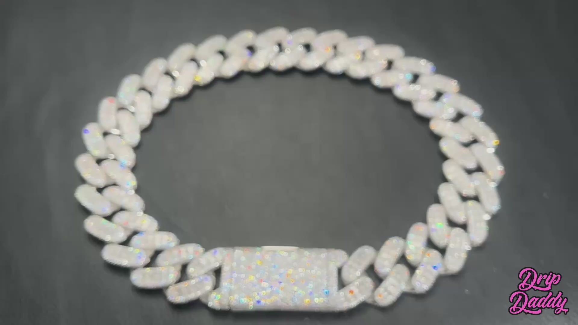 A rotating product video of Drip Daddy’s Capsule – Mixed-Cut Cuban Chain in yellow gold plating. The camera highlights the alternating round and emerald-cut moissanite stones set into the links, showing the shimmer and craftsmanship from multiple angles. The Drip Daddy logo is displayed in pink at the bottom right.