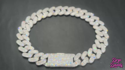 A rotating product video of Drip Daddy’s Capsule – Mixed-Cut Cuban Chain in yellow gold plating. The camera highlights the alternating round and emerald-cut moissanite stones set into the links, showing the shimmer and craftsmanship from multiple angles. The Drip Daddy logo is displayed in pink at the bottom right.