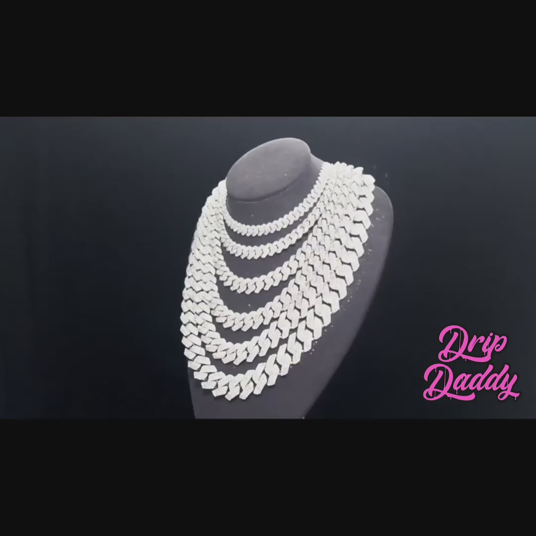 A cinematic close-up video of the Power Link Cuban chain, featuring oversized 20mm to 27mm links set with shimmering moissanite stones. The camera smoothly pans and rotates, capturing the icy sparkle of each stone as the chain reflects light. The thick Cuban design emphasizes bold luxury and statement style.